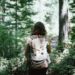 Mujer caminando por el bosque con mochila