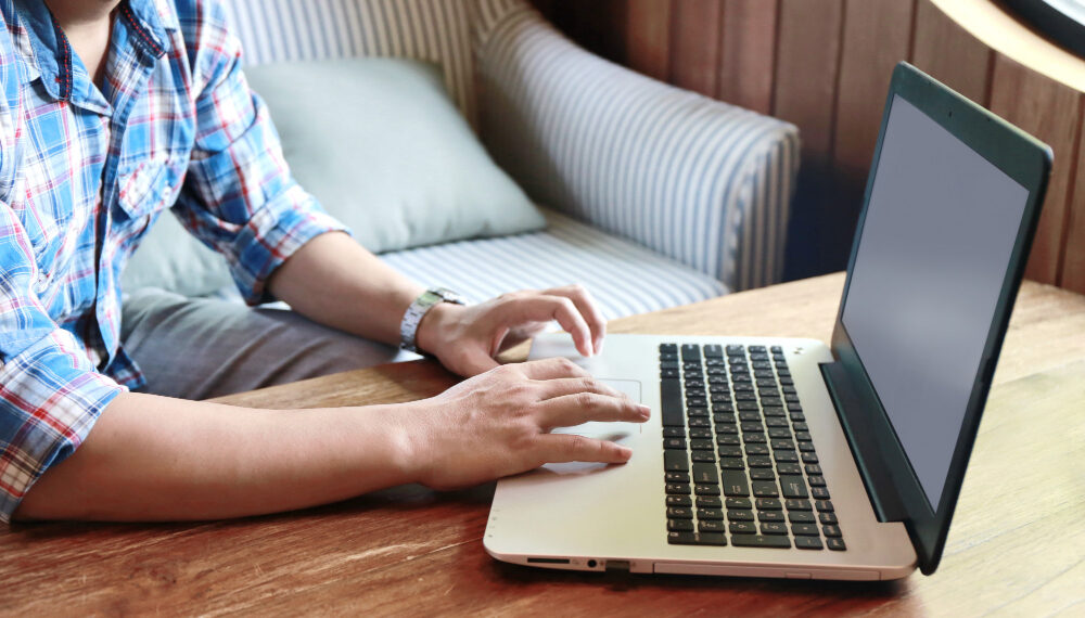 Hombre trabajando con portatil sobre mesa