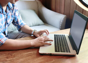 Hombre trabajando con portatil sobre mesa